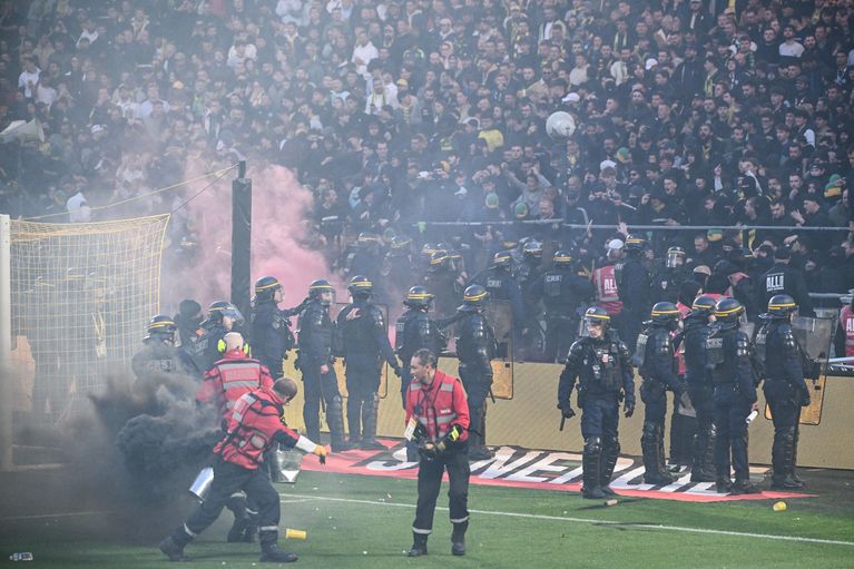 Nantes supporters return to their stand under heavy police presence after pitch invasion and smoke bomb incident