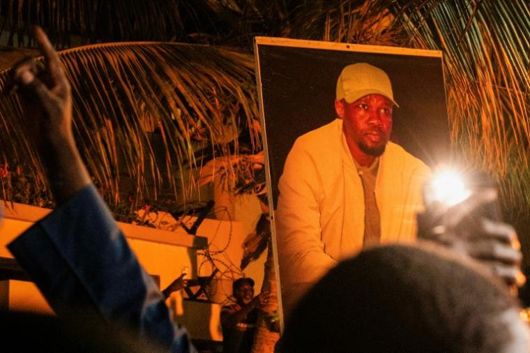 Supporters of Ousmane Sonko display his portrait outside his Dakar home on May 23, 2026