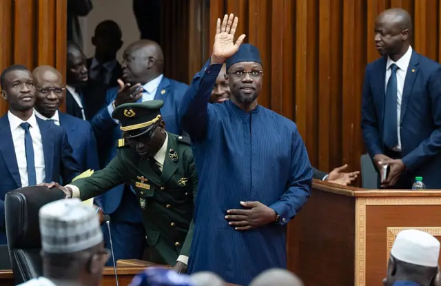 Ousmane Sonko salue les membres du Parlement à son arrivée à Dakar, le 28 novembre 2025, pour prononcer son discours devant l'Assemblée nationale.