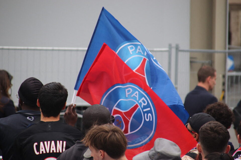 PSG fans celebrating a previous Champions League parade on the Champs-Élysées in Paris