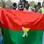 Supporters of the AES wave homemade Burkina Faso flags (January 2024 archive)